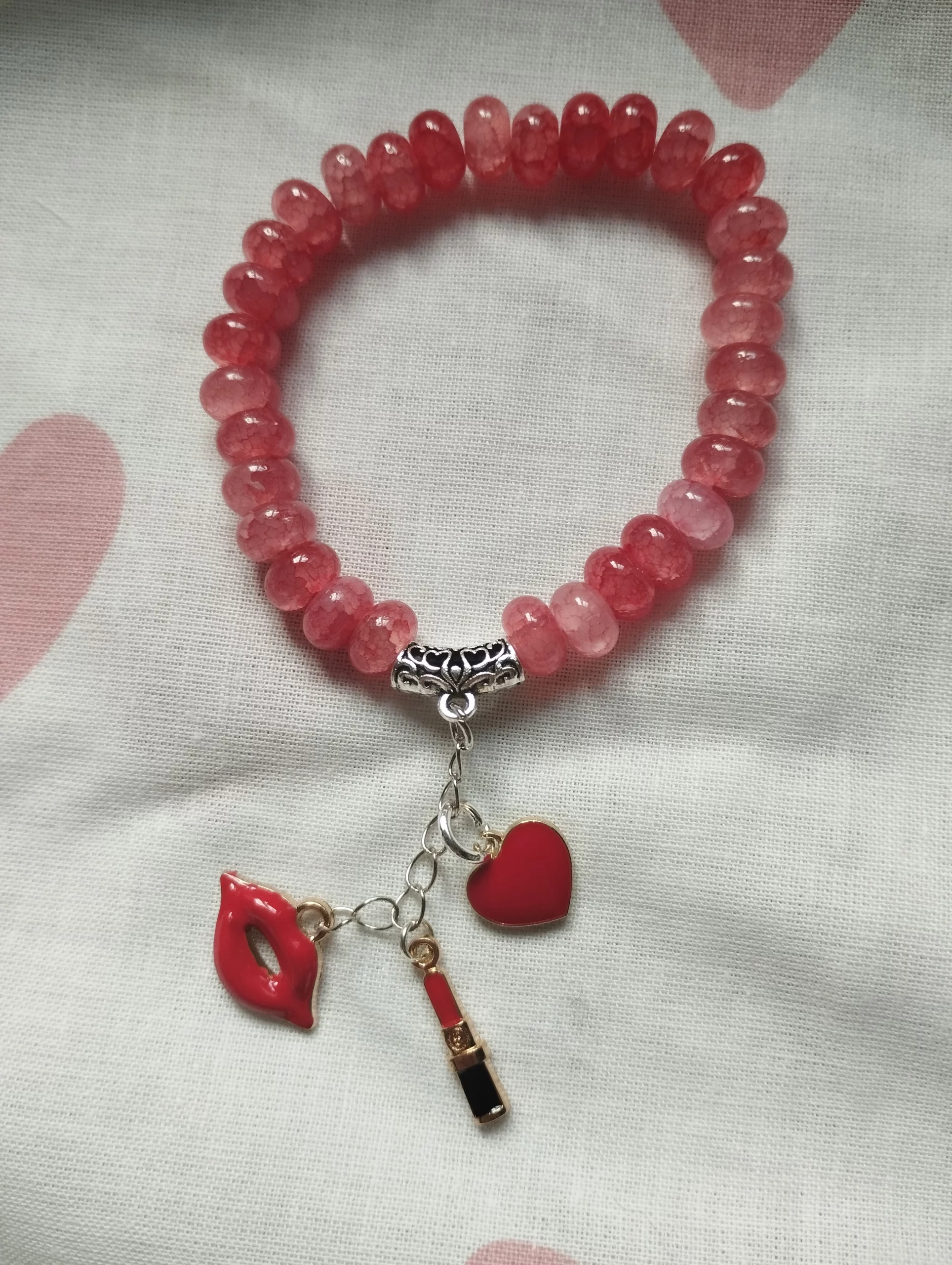bracelet de perles rouge avec des perles en forme de bouche, de rouge à lèvres et un coeur